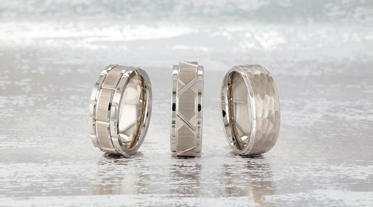 Three tungsten rings on a metallic background.