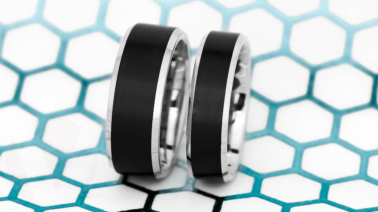 Two black wedding bands on a blue background.