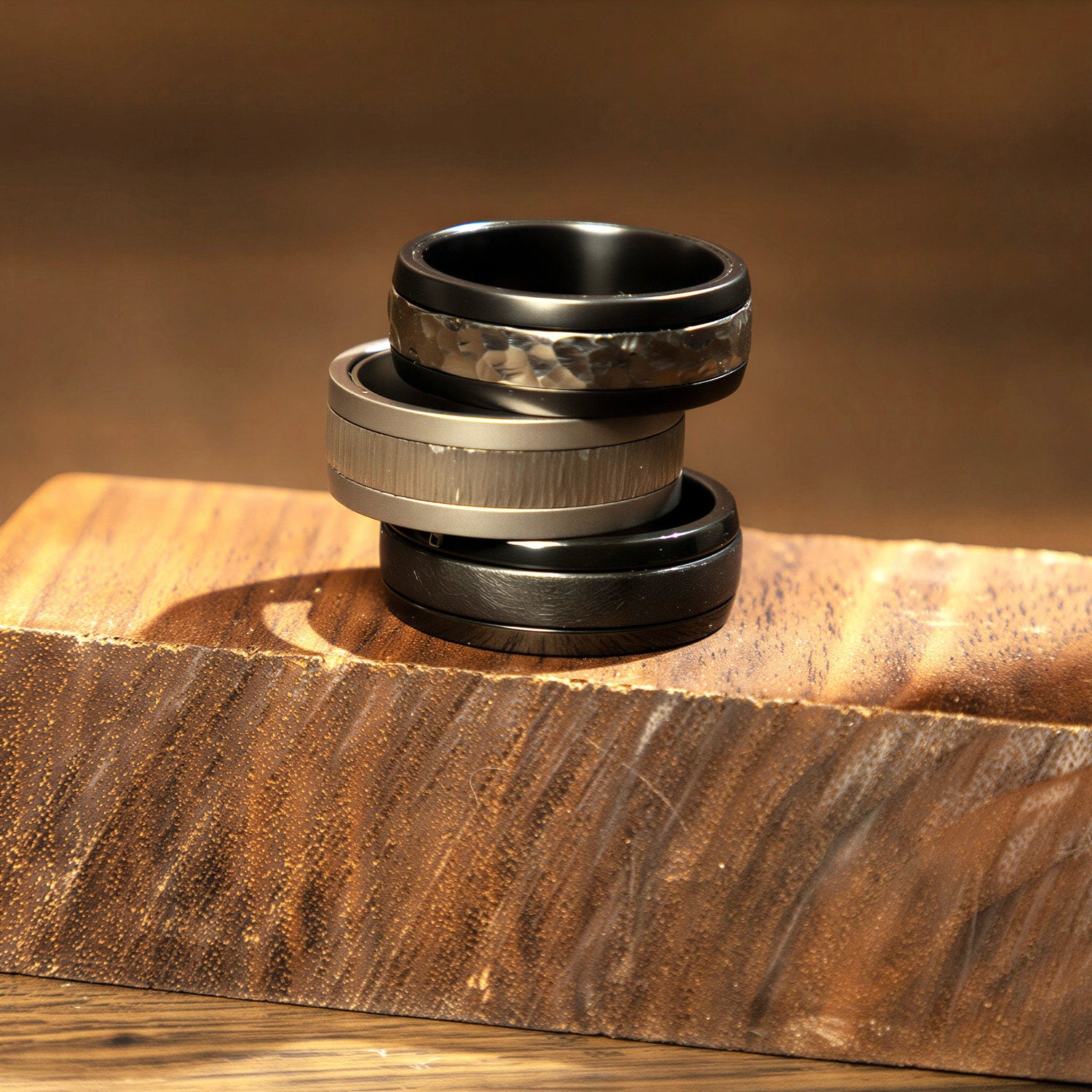 A minimal assortment of wedding bands for men and women displayed vertically on a slightly reflective white surface.