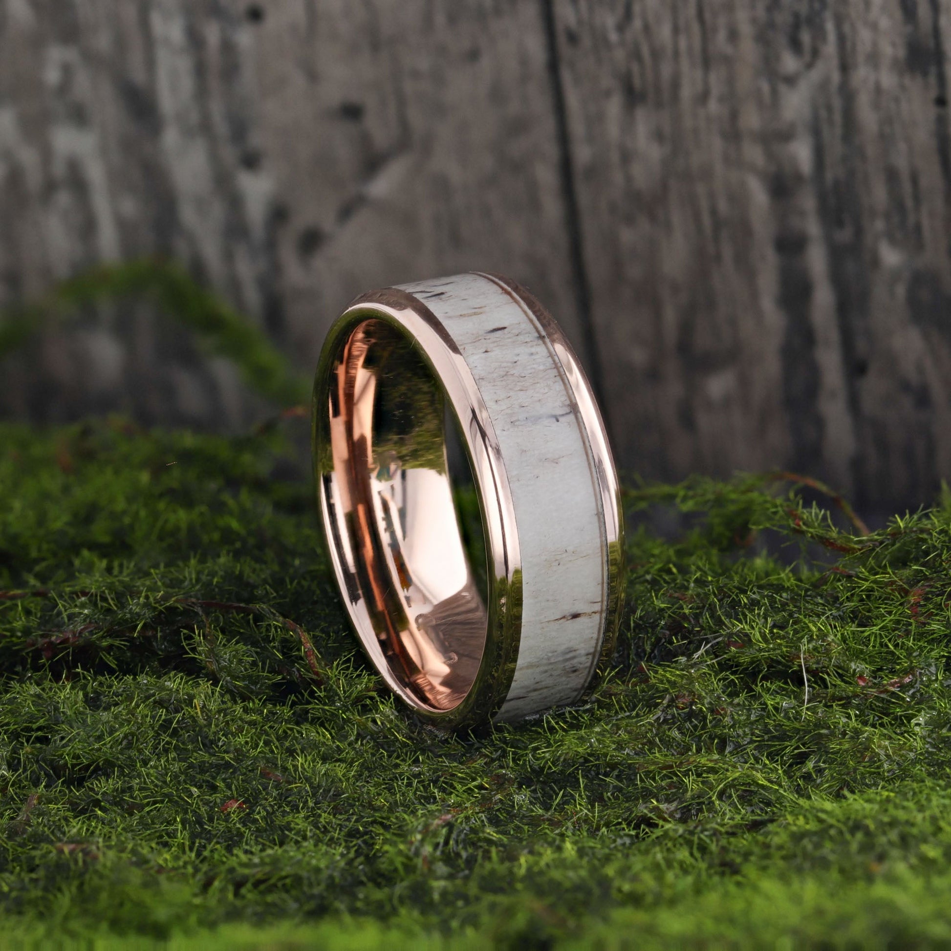 Two-tone ring on a mossy surface with a wood wall background