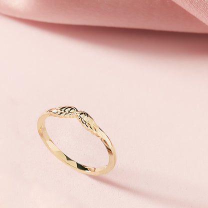 Gold ring on a pink fabric background