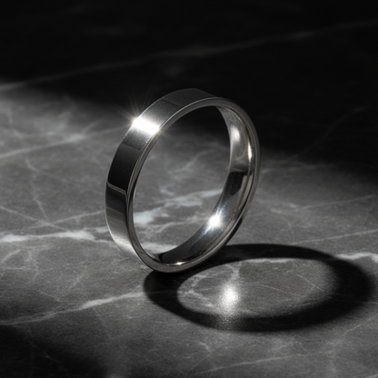 Silver ring on a marble surface with a dark background