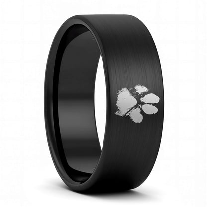 A custom paw print brushed black tungsten men's wedding band displayed on a plain white background.