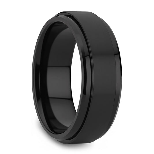 A black metallic band ring with a beveled edge and a smooth, polished finish, shown at an angle on a white background.