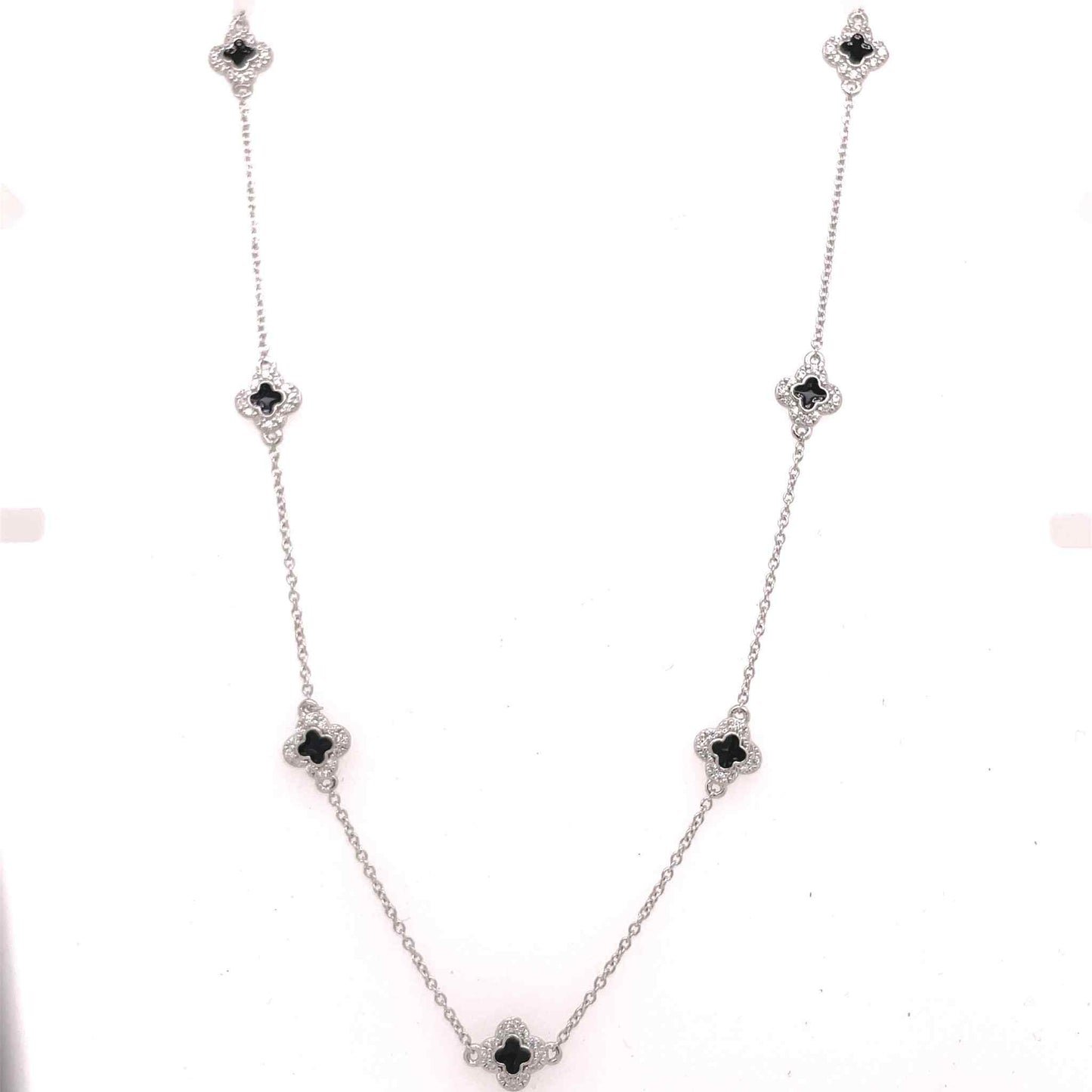 A enamel clover station necklace with simulated diamonds displayed on a neutral white background.