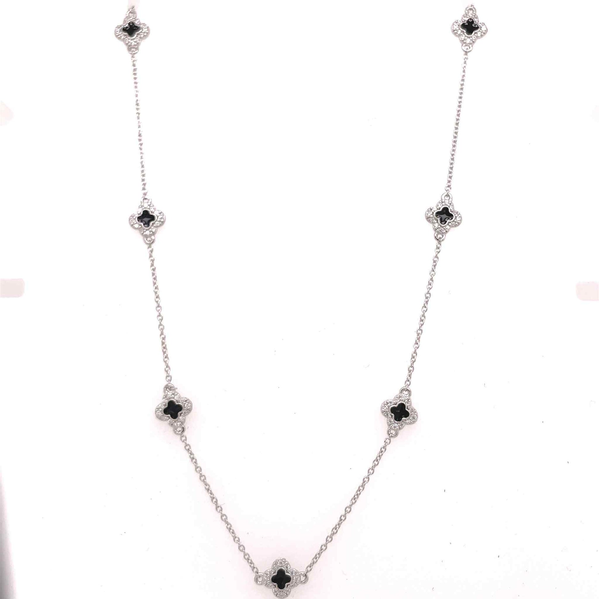 A enamel clover station necklace with simulated diamonds displayed on a neutral white background.