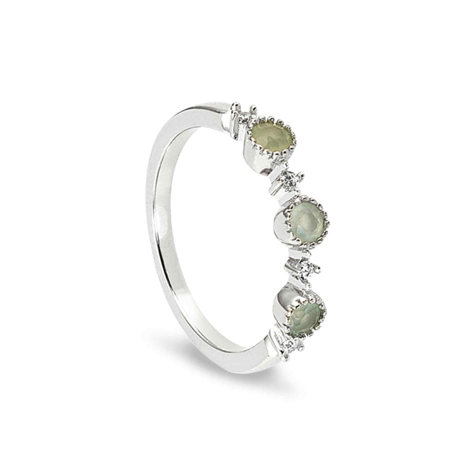 A green three stone ring with simulated diamonds displayed on a neutral white background.
