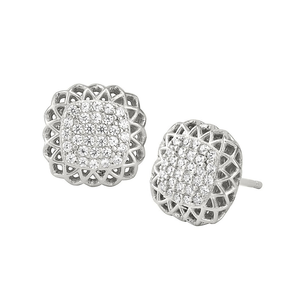 A pillow with filigree edge earrings with simulated diamonds displayed on a neutral white background.