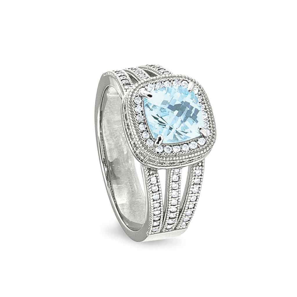 A ring with simulated aquamarine and simulated diamonds displayed on a neutral white background.