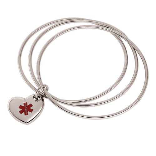 A stainless steel medical bangle bracelet with heart medical tag displayed on a neutral white background.