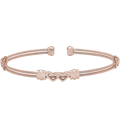 A two cable bracelet with two linked hearts displayed on a neutral white background.