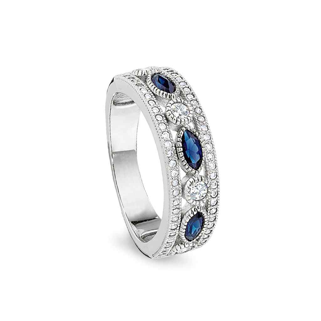 A vintage-style ring with synthetic blue sapphire & simulated diamonds displayed on a neutral white background.