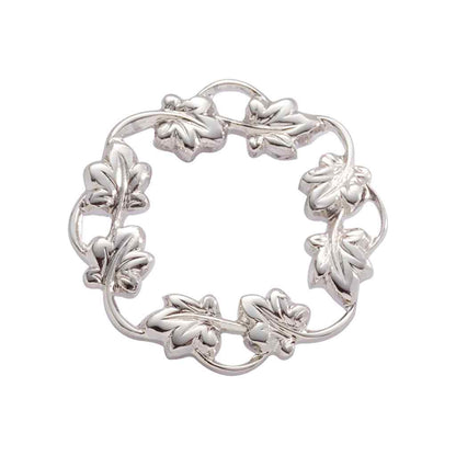 A wreath pin displayed on a neutral white background.